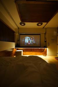 sypialnia z telewizorem z płaskim ekranem i łóżkiem w obiekcie Vintage54 Hotel Ayutthaya w mieście Phra Nakhon Si Ayutthaya