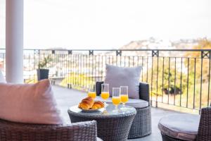 a table with two glasses of orange juice and croissants at Villa Vacuna in Funchal