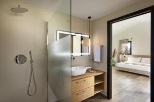 a bathroom with a shower with a sink and a tub at Uddastri Retreat in Arzachena