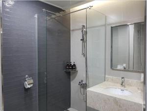 a bathroom with a glass shower and a sink at Hotel Ciel Dongtan in Hwaseong