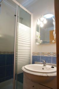 a bathroom with a sink and a shower at Quartos confortáveis em casa próximo ao Mosteiro in Batalha