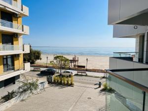 a view of the beach from the balcony of a building at DAMAR Infinity Beach and Pool Mamaia- private parking in Mamaia Sat/Năvodari