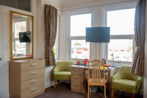 a room with a desk and chairs and windows at Revado Hotel in Norwich