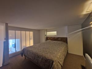 um quarto com uma cama e uma grande janela em Superbe appartement au bord de l'océan em Biarritz