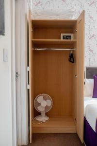 a small closet with a fan in a bedroom at Revado Hotel in Norwich