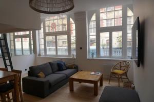 uma sala de estar com um sofá e uma mesa em Superbe appartement au bord de l'océan em Biarritz