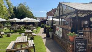 een groep picknicktafels en parasols naast een gebouw bij Georgian House Hotel in Derby