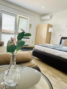 a living room with a vase with flowers on a table at Attila Studio Apartments in Hajdúszoboszló