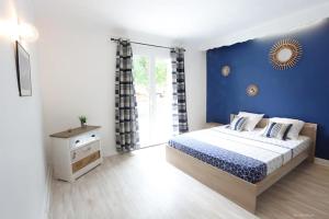 um quarto com uma cama e uma parede azul em L'immeuble les 3C em Saint-Palais-sur-Mer
