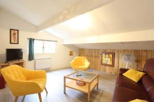 - un salon avec un canapé et des fauteuils jaunes dans l'établissement L'immeuble les 3C, à Saint-Palais-sur-Mer