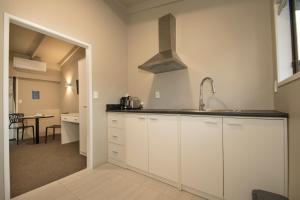 a kitchen with white cabinets and a sink at Middlemore Motel in Auckland