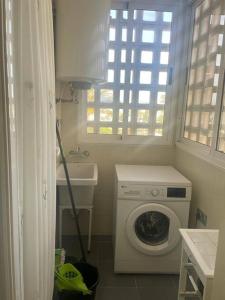 uma lavandaria com uma máquina de lavar roupa e um lavatório em Vereda Golf - Apartamento em Roquetas de Mar
