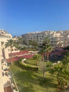 Blick auf einen Park mit Palmen und Gebäuden in der Unterkunft Vereda Golf - Apartamento in Roquetas de Mar