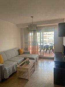 ein Wohnzimmer mit einem Sofa und einem Tisch in der Unterkunft Vereda Golf - Apartamento in Roquetas de Mar