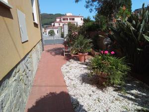 einen Gehweg mit Topfpflanzen und ein Gebäude in der Unterkunft Appartamento Loretta in Marciana Marina