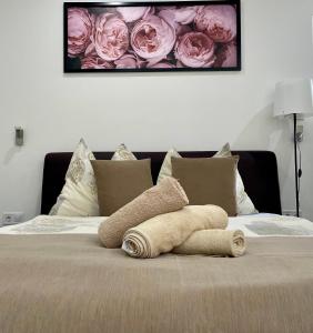 ハイドゥソボスローにあるAttila Studio Apartmentsのベッドの上にバラを敷いたタオル