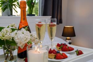 une table recouverte de deux verres de champagne et de fraises dans l'établissement Maya's Flats & Resorts - Gdańsk Szopy, à Gdańsk