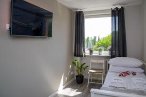 ein kleines Schlafzimmer mit einem Bett und einem Fenster in der Unterkunft Maya's Flats & Resorts - Gdańsk Szopy in Danzig