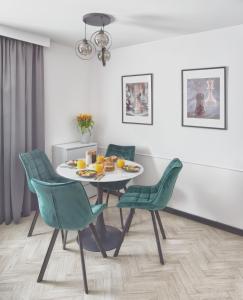 a dining room with a table and green chairs at Royal Plater in Łeba
