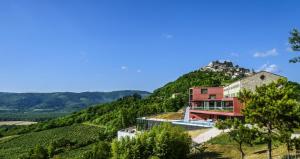 uma casa no lado de uma colina com árvores em Winery & Design hotel ROXANICH em Motovun