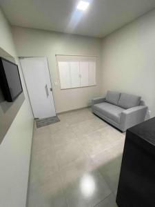 ein Wohnzimmer mit einem Sofa und einem TV in der Unterkunft Vêneto Flat Residence (AP-11) in Primavera do Leste