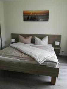 1 dormitorio con 1 cama grande con sábanas y almohadas blancas en Apart Schleswig, en Schleswig