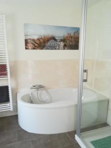 a bath tub in a bathroom with a picture on the wall at Apart Schleswig in Schleswig