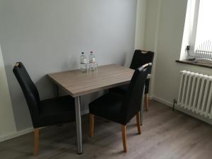 a wooden table with two bottles of water and two chairs at Apart Schleswig in Schleswig +2 photos