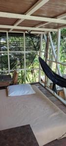 a bed with a hammock in a room with windows at hijau in Tjakranegara