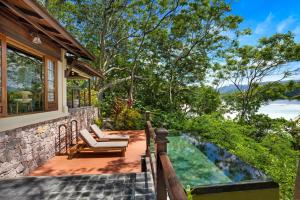JA Enchanted Island Resort Seychelles في Round Island: فناء مع كراسي وحمام سباحة على المنزل