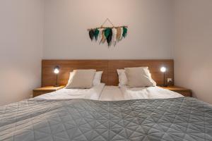 una camera con un grande letto con due lampade di Apartament Zielony Jodłowa - z prywatną sauną! by Dream Apart a Szczyrk