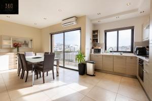 a kitchen and dining room with a table and chairs at Beautiful, spacious 3BR home with private Balcony with 360 Estates in St Julian's