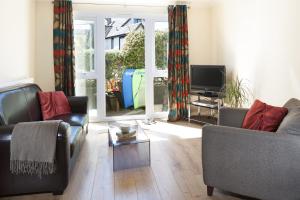 a living room with two couches and a tv at Gwithian Holidays in Hayle