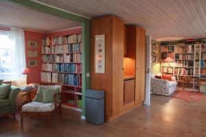 a living room with book shelves filled with books at The Wine Lodge-Bo på vingård in Vittsjö
