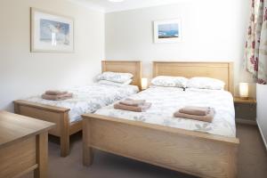 two beds in a bedroom with towels on them at Gwithian Holidays in Hayle