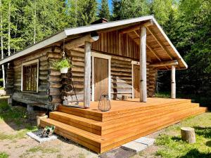 Cabaña de madera con porche y terraza en Iken Mökit, en Heinola