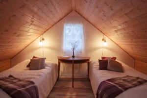 a attic room with two beds and a window at The Wine Lodge-Bo på vingård in Vittsjö