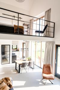 a living room with a table and chairs and a kitchen at Het Landzicht 