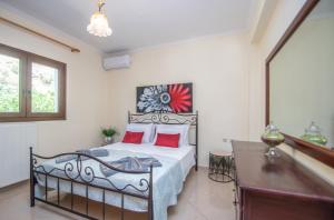 een slaapkamer met een bed met rode kussens bij Green Lagoon Villa by "elite" in Zakynthos