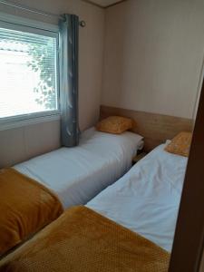 two beds in a small room with a window at Happy place no4 in Ringwood
