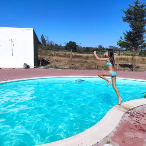 een jong meisje springend in een zwembad bij Vila da Laje - Onde a Natureza o envolve - Serra da Estrela in Oliveira do Hospital