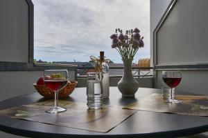 een tafel met twee glazen wijn en een vaas met bloemen bij Atlantic 05 in Grömitz