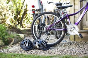 a purple bike parked next to helmets on the ground at Gwithian Holidays in Hayle