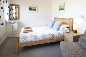 a bedroom with a bed and a chair at Gwithian Holidays in Hayle