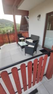 a balcony with chairs and a table on a deck at Domek na górce 2 in Krościenko