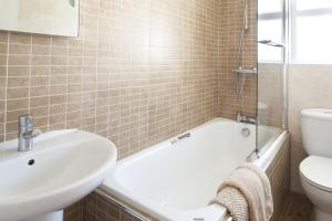 a bathroom with a tub and a sink and a toilet at Gwithian Holidays in Hayle