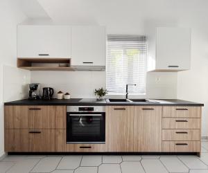 a kitchen with white cabinets and a black appliance at Anna's Apartment in Kato Daratso