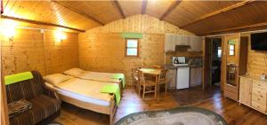 a small room with a bed and a kitchen at Mazurski Domek in Mikołajki