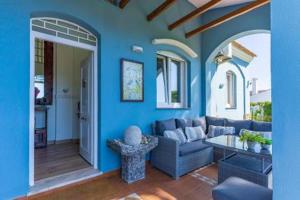 Sala de estar azul con sofá y mesa en Chalet Azul en Aljaraque
