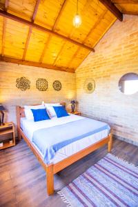 a bedroom with a large bed with blue pillows at Pousada Sonho Meu in Camanducaia